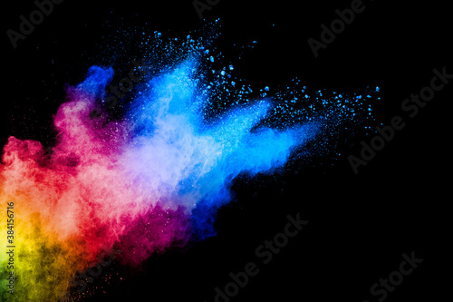 Colorful powder explosion on black background. Abstract pastel color dust particles splash.