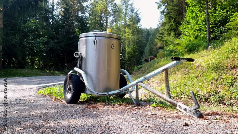 Milk container on wheels on a roadside.