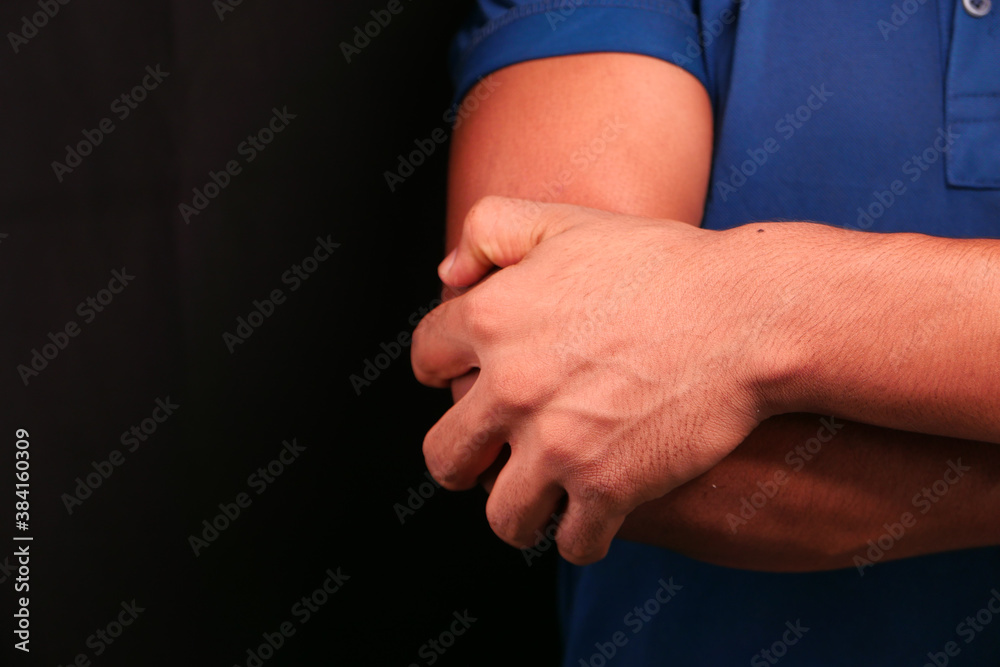 man with elbow pain isolated in black. Pain relief concept.