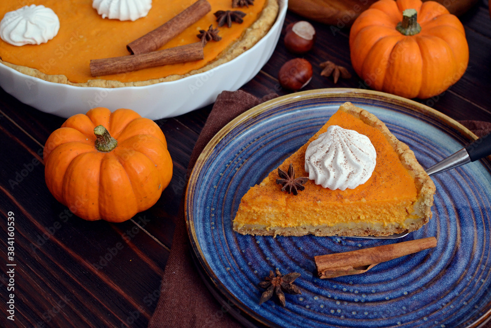pumpkin pie with cinnamon and cream in a cut. Autumn table setting for Thanksgiving and Halloween. pumpkins, cinnamon sticks, plates, wooden background
pumpkin pie with cinnamon and cream in a cut. Autumn table setting for Thanksgiving and Halloween. pumpkins, cinnamon sticks, plates, wooden background