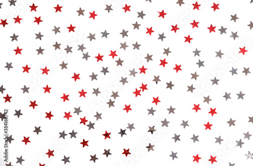 Red and silver stars glitter on a white isolated background. Festive holiday backdrop.