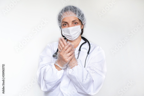 Dotkor woman in white coat, gloves and mask. Protection against infections during the COVID epidemic. Medicine and health concept. The main focus is on the hands. Copy space photo