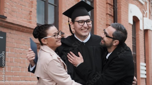 Graduation from university: student hugs his parents, they are happy and proud