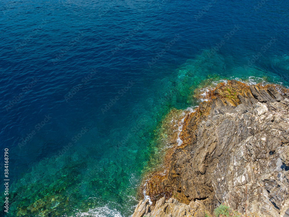 Aerial top view of turquoise sea waves hitting rocks. Amazing rock cliff seascape in the Italian coastline. Drone photography Aerial top view of turquoise sea waves hitting rocks. Amazing rock cliff seascape in the Italian coastline. Drone photography