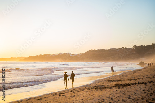 Falesia beach with golden sand and fog at sunset on the Atlantic ocean. Olhos de Agua, Algarve, Portugal.