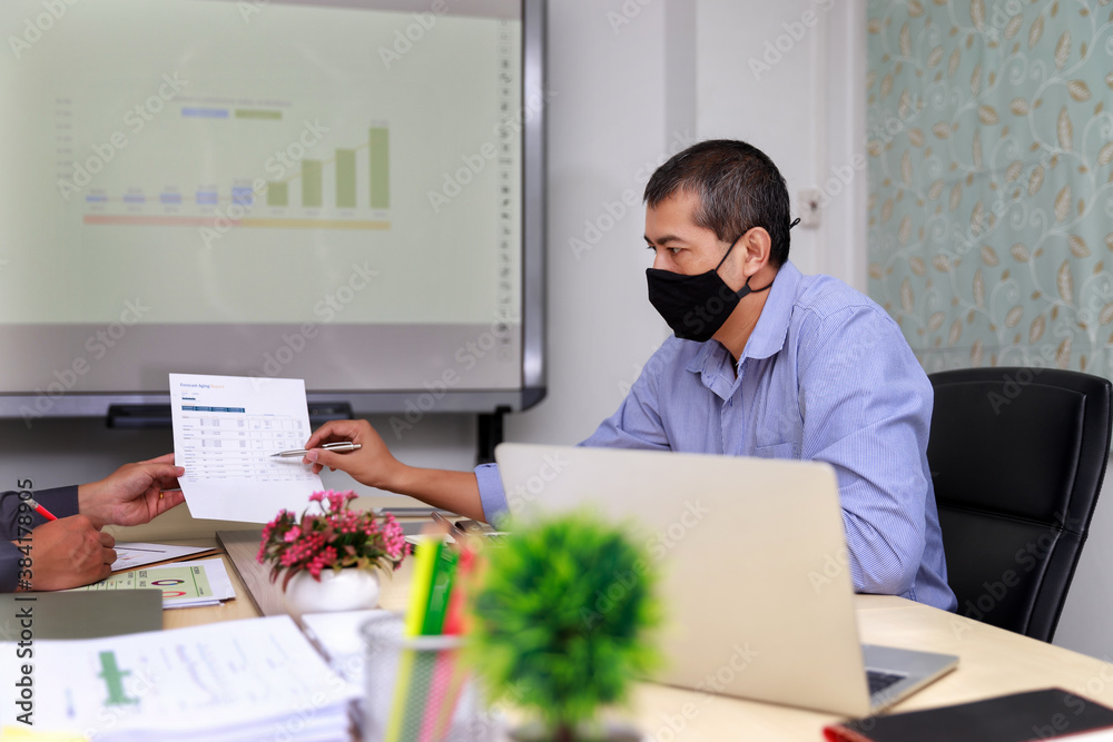 Businessmen wearing protective masks discussing and work together in meeting room. Social distance practice prevent coronavirus COVID-19. Businessmen wearing protective masks discussing and work together in meeting room. Social distance practice prevent coronavirus COVID-19.