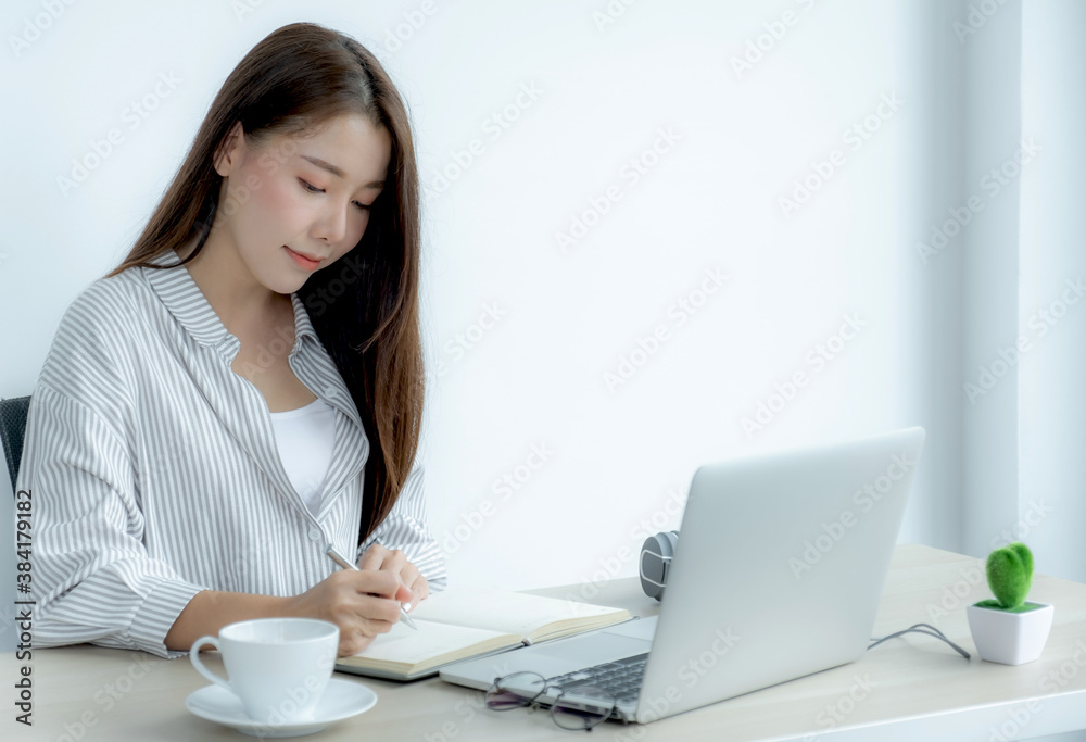 Young woman student taking notes watching laptop study online class video conference education elearning course from home Young woman student taking notes watching laptop study online class video conference education elearning course from home