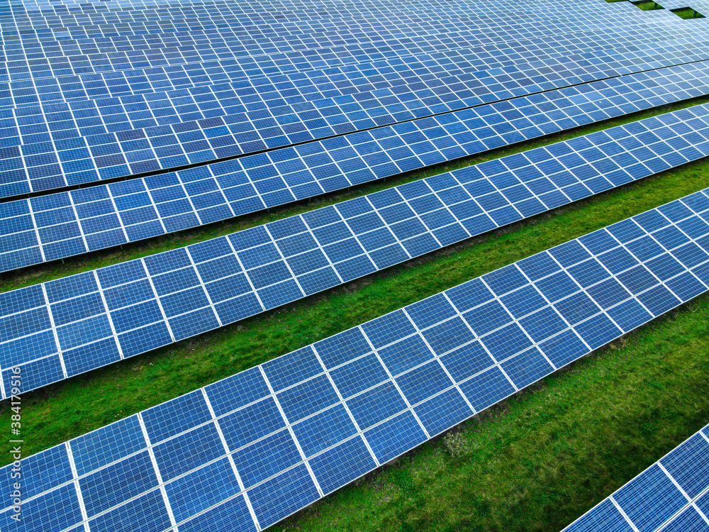 Solar power farm on a grass field with rows of modern panels collecting energy from the sun. Solar power farm on a grass field with rows of modern panels collecting energy from the sun.
