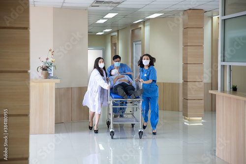 The doctor was rushing into the intensive care unit in the emergency bed, the patient was very sick. The doctor is pushing the patient bed.