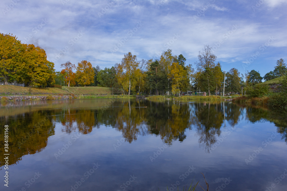 Obraz premium colorful trees and a river in a morning Symmetry reflections on the water. 