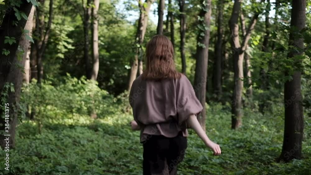 Young woman running through the forest wearing linen clothes in slow motion Young woman running through the forest wearing linen clothes in slow motion
