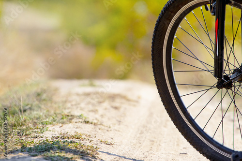Bicycle wheel on a background of a dirt road, off-road cycling © Volodymyr