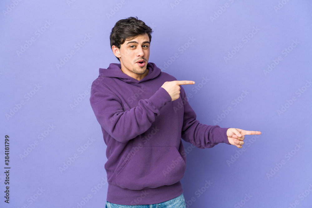 Young cool man pointing with forefingers to a copy space, expressing excitement and desire. Young cool man pointing with forefingers to a copy space, expressing excitement and desire.
