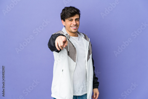 Young cool man pointing to front with fingers.