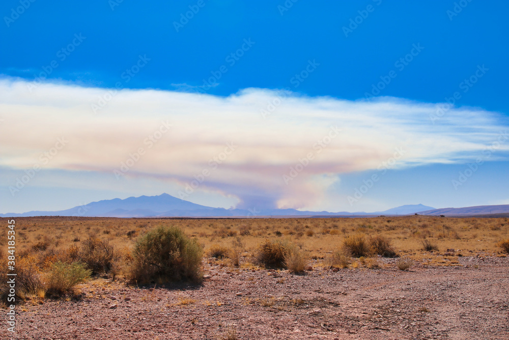 A wildfire far away in a forest, look over the desert in arizona
