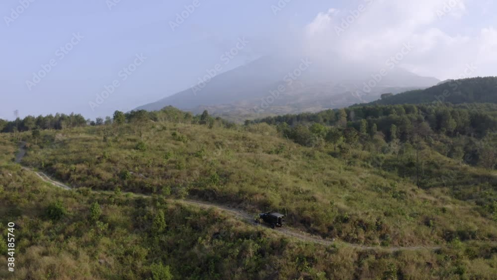Aerial view of off road vehicle moving on the hills with misty mountain in Kuningan, Indonesia. Shot in 4k resolution Aerial view of off road vehicle moving on the hills with misty mountain in Kuningan, Indonesia. Shot in 4k resolution