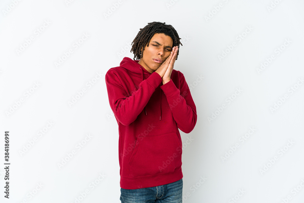 Young african american rasta man yawning showing a tired gesture covering mouth with hand. Young african american rasta man yawning showing a tired gesture covering mouth with hand.