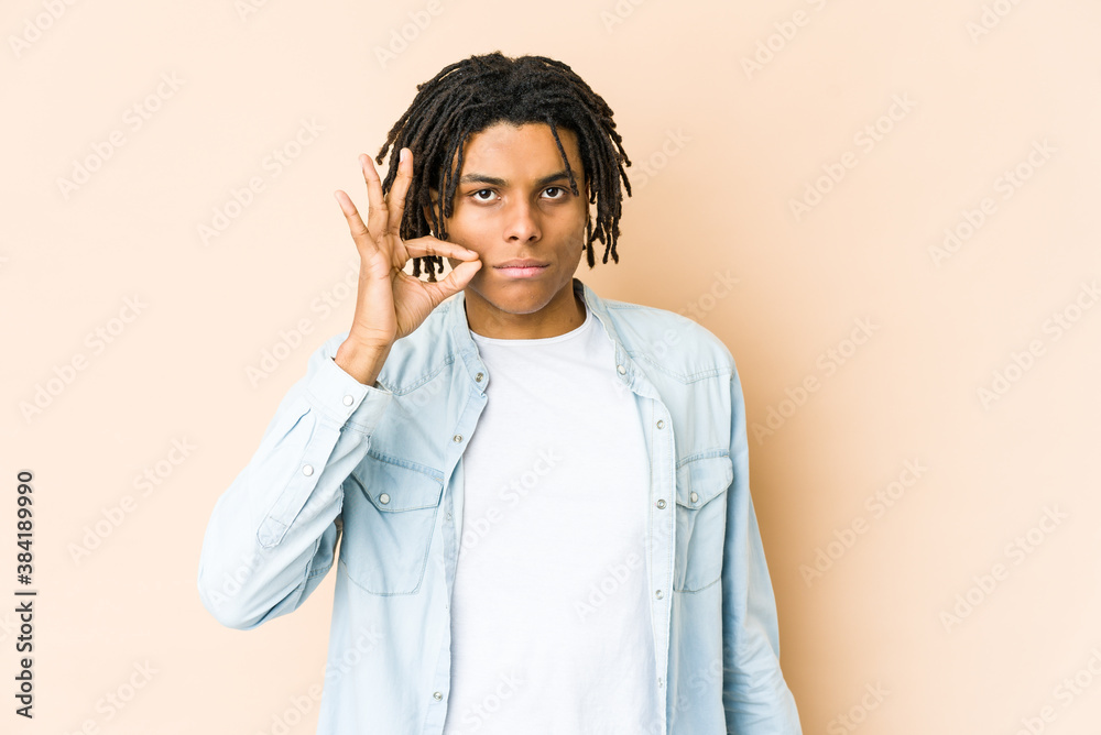 Young african american rasta man with fingers on lips keeping a secret. Young african american rasta man with fingers on lips keeping a secret.