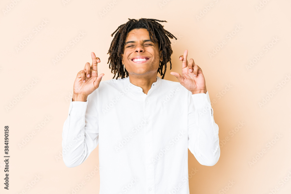 Young african american rasta man crossing fingers for having luck Young african american rasta man crossing fingers for having luck