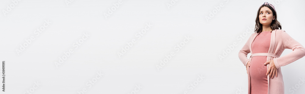 © LIGHTFIELD STUDIOS - website header of worried pregnant woman in headband touching belly and looking away isolated on white