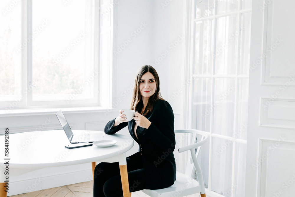 Girl in dark clothes, suit working on a laptop, lawyer, consultant, specialist, work in the office and from home, Internet, communication with colleagues, coffee break, tea, Cup, water, snack Girl in dark clothes, suit working on a laptop, lawyer, consultant, specialist, work in the office and from home, Internet, communication with colleagues, coffee break, tea, Cup, water, snack