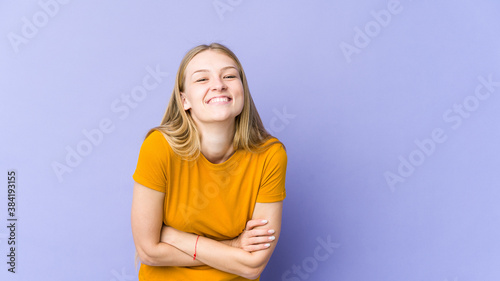 Young blonde woman isolated on purple background laughing and having fun.