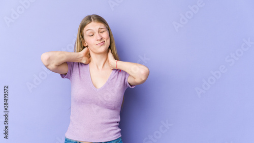 Young blonde woman isolated on purple background suffering neck pain due to sedentary lifestyle.