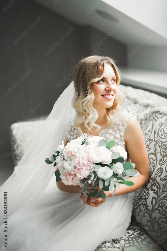 Gorgeous bride in robe posing and preparing for the wedding ceremony face in a room Gorgeous bride in robe posing and preparing for the wedding ceremony face in a room