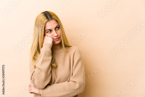 Young blonde caucasian woman who feels sad and pensive, looking at copy space.