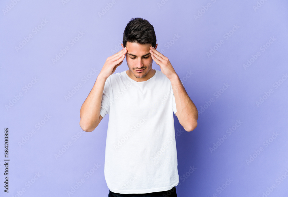 Young caucasian man isolated on purple background touching temples and having headache. Young caucasian man isolated on purple background touching temples and having headache.