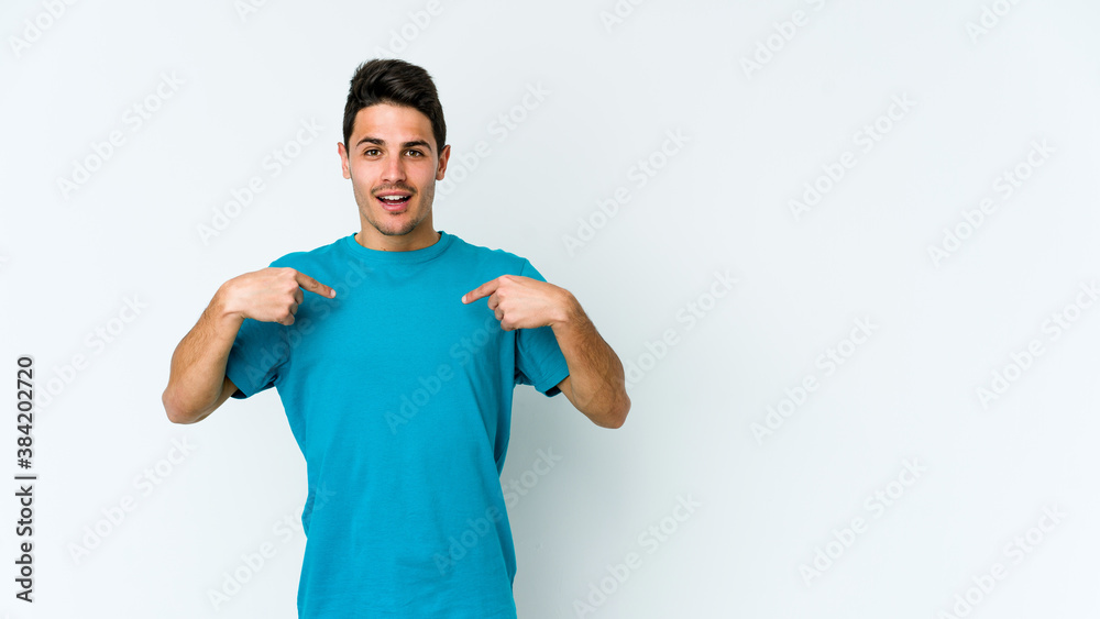 Young caucasian man isolated on white background surprised pointing with finger, smiling broadly. Young caucasian man isolated on white background surprised pointing with finger, smiling broadly.