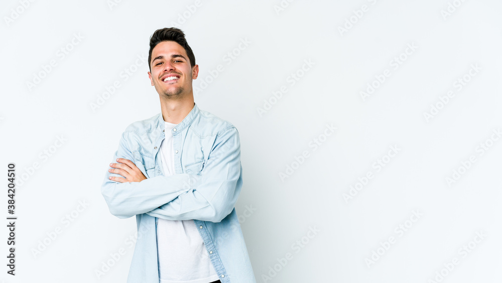 Young caucasian man isolated on white background who feels confident, crossing arms with determination. Young caucasian man isolated on white background who feels confident, crossing arms with determination.