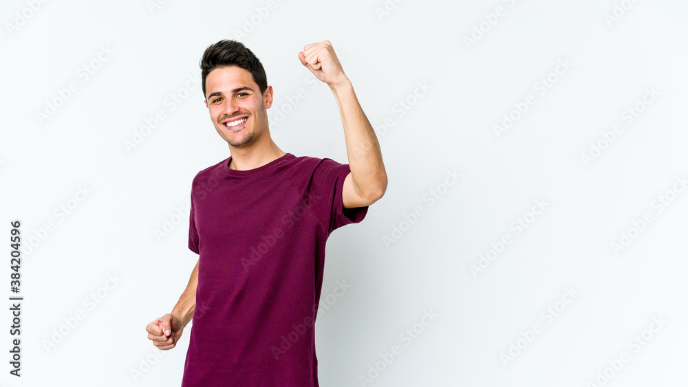 Young caucasian man isolated on white background cheering carefree and excited. Victory concept.