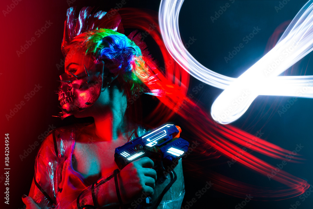 Beautiful cyberpunk woman with mohawk hairstyle in spiked skull mask holding a handgun.