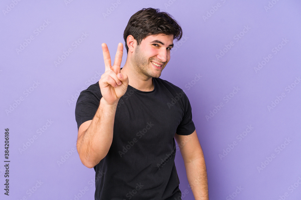 Young man isolated on purple background showing number two with fingers. Young man isolated on purple background showing number two with fingers.
