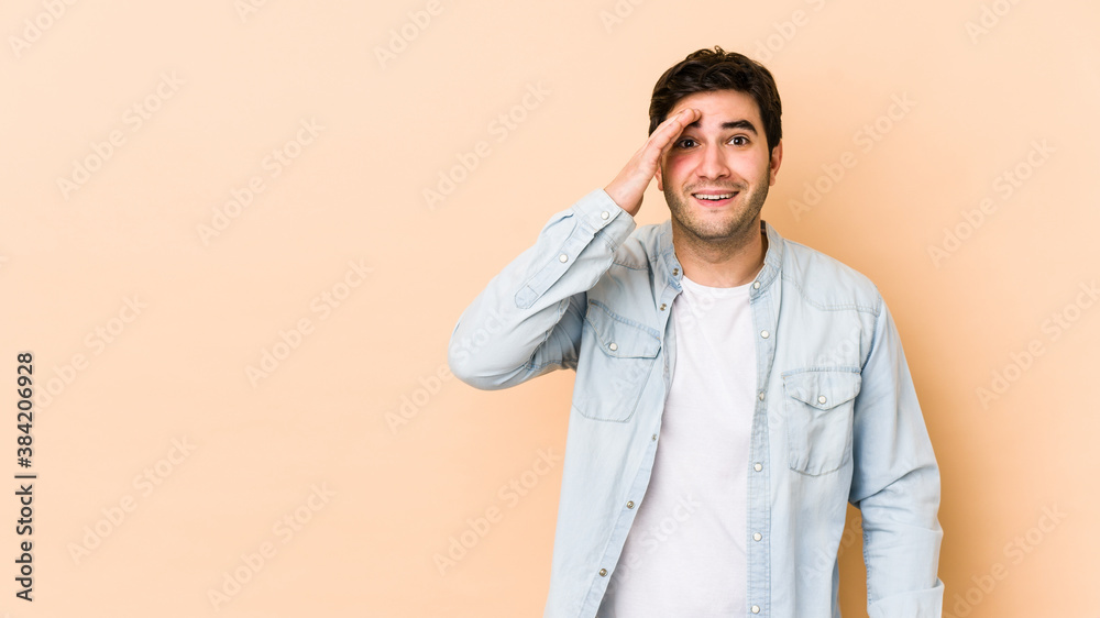 Young man isolated on beige background shouts loud, keeps eyes opened and hands tense. Young man isolated on beige background shouts loud, keeps eyes opened and hands tense.