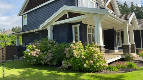 Establishing shot of two story painted wood luxury house with veranda, big tree and nice landscape in Vancouver, Canada, North America. Day time on September 2020. Pan right.