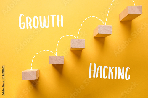 Modern word - growth hacking. New Buzzword, Top view of woodblock with a yellow background. Close up photo