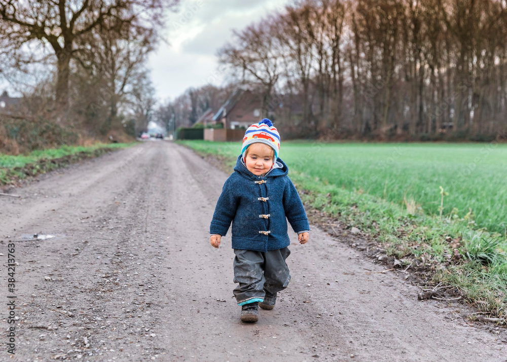 Fototapeta premium Happy toddler walking on footpath