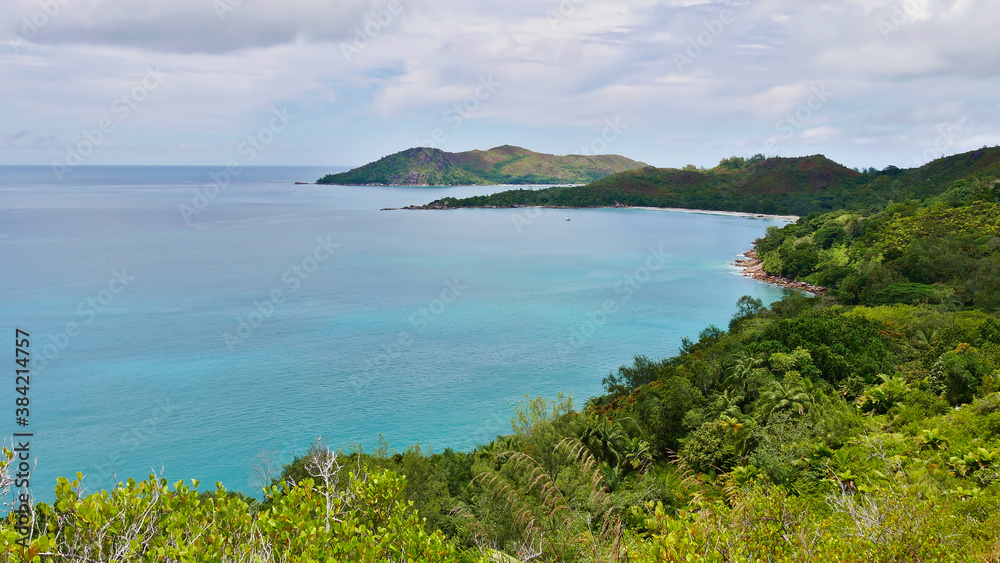 Panoramic view of the northern coast of Praslin island, Seychelles including bay with popular beach Anse Lazio, granite rock formations and tropical rainforest landscape.