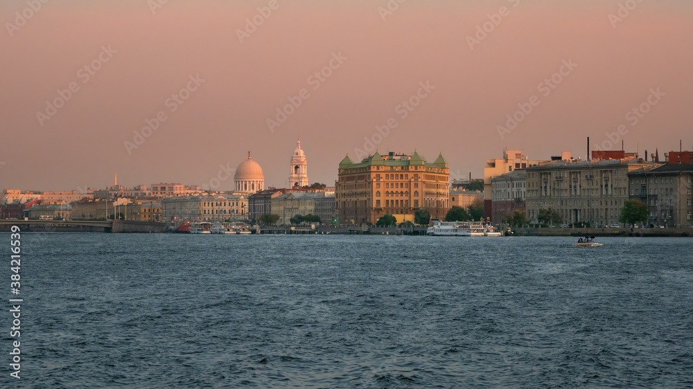 Beautiful pink sunset in Saint Petersburg. Embankment with ancient architecture in the evening