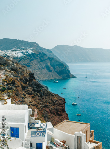 Houses in the mountains overlooking the sea with boats oia santorini greece