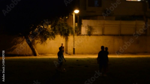 silhouette of children playing in the evening park. very low light soft focus.
