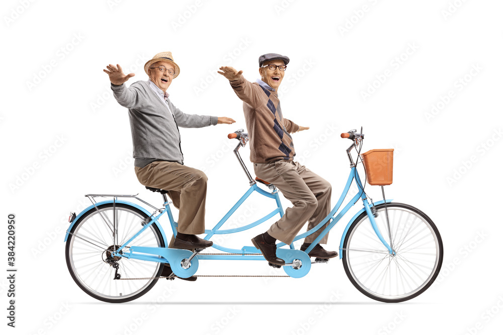 Cheerful elderly men riding a tandem bicycle and spreading arms