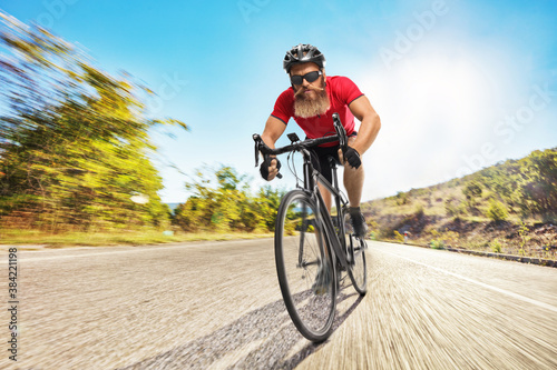 Bearded cyclist with a helmet riding a bicycle
