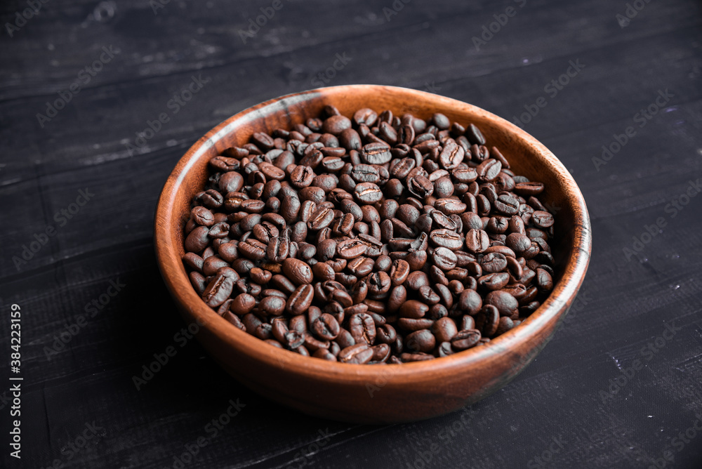 Fototapeta premium Roasted coffee beans in wooden bowl. Top view. Copy space. Morning concept