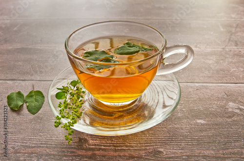 Tulsi tea served in a glass cup with tulsi or holi basil leaves. Tulsi has many benefits for body and brain.