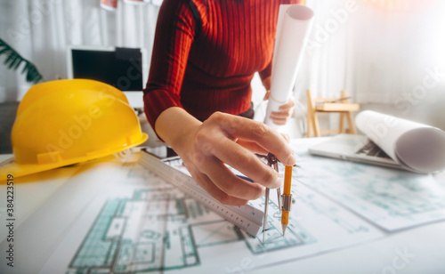 Two colleagues discussing data working and tablet, laptop with on on architectural project at construction site at desk in office