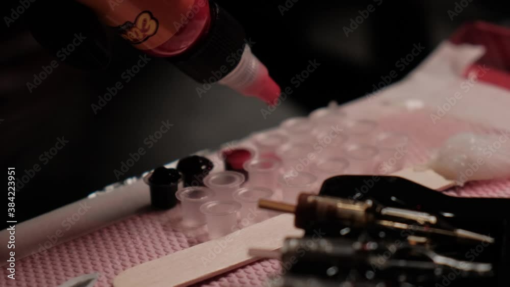 Tattoo master pours paints in a container close-up. Preparation for tattooing. Tattoo master pours paints in a container close-up. Preparation for tattooing.
