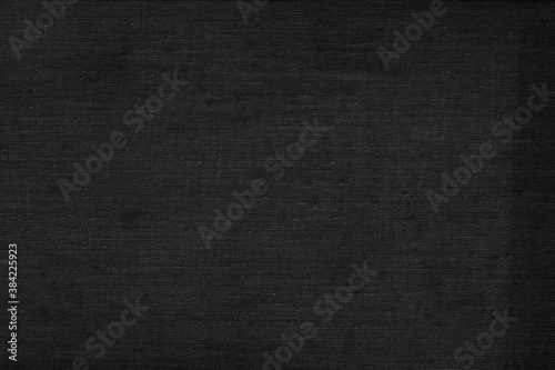 Black natural linen texture as a backdrop. Abstract cotton towel mockup template fabric on the background. Cloth wallpaper of artistic grey wale linen canvas texture for the painting.  